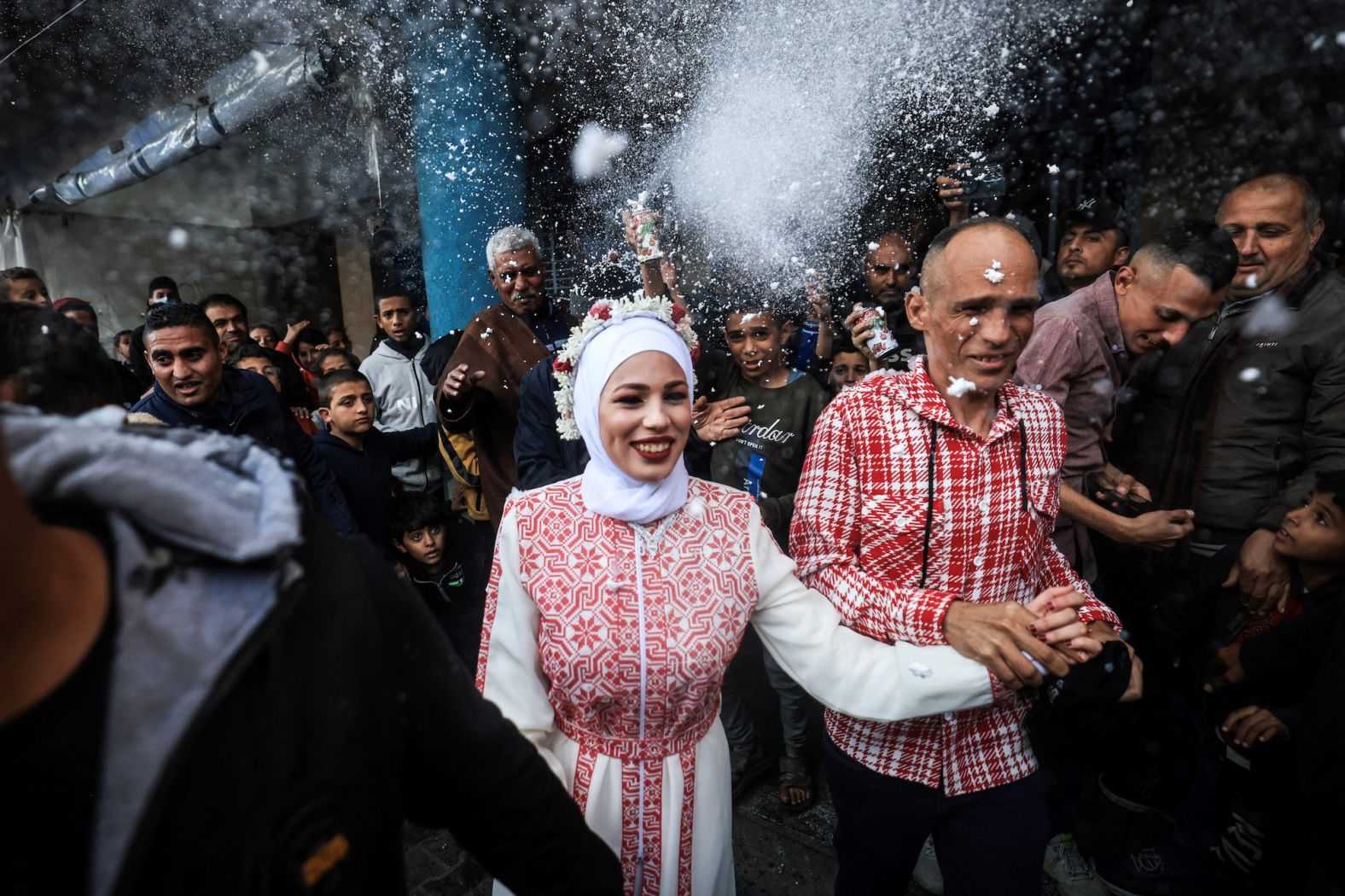 Palestinian bride Afnan Jibril is escorted by her father, right, during her wedding at the UNRWA school in the Al-Salam neighborhood of Rafah, Gaza, on Friday, January 12.