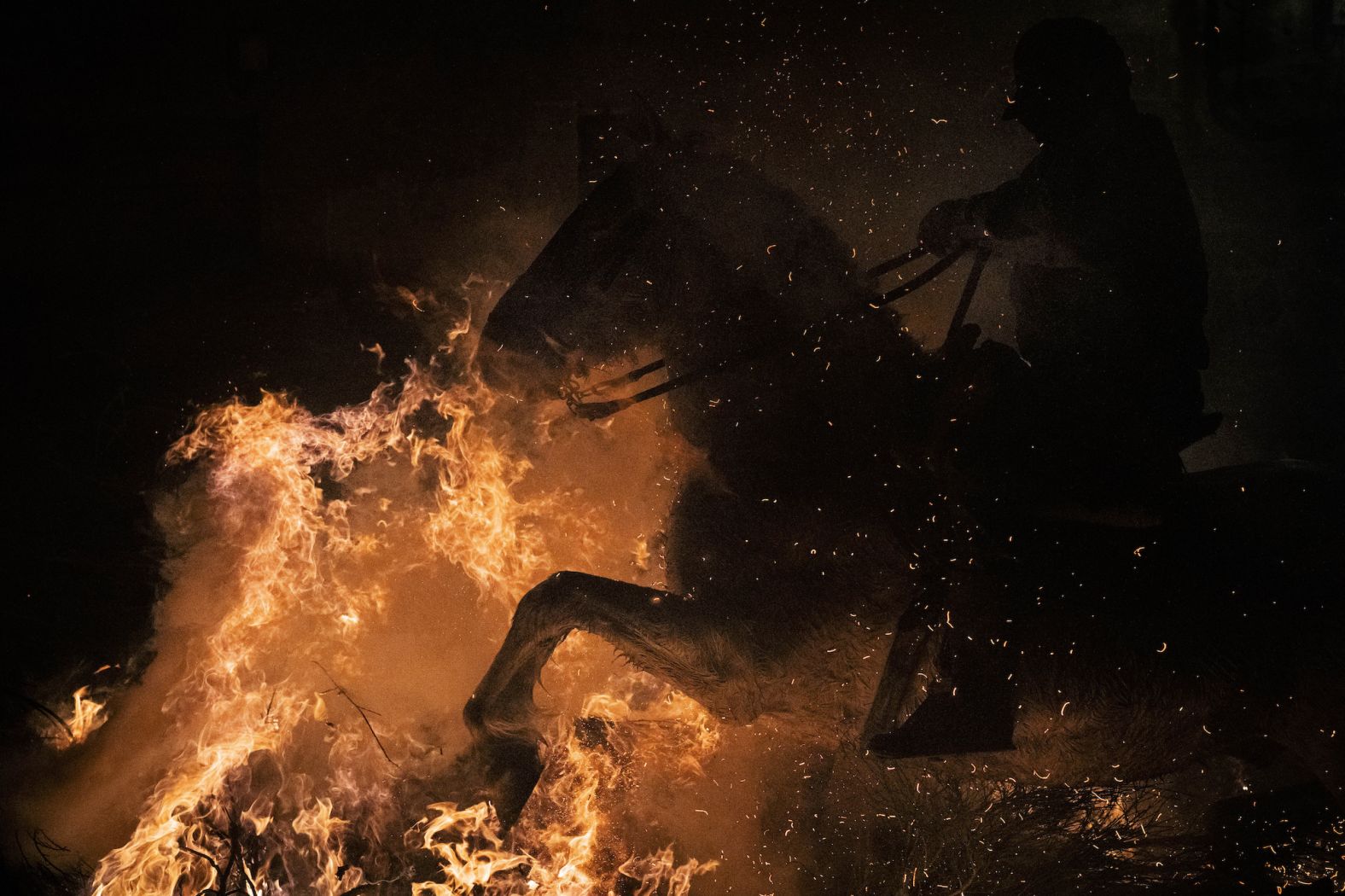 A man rides a horse through a bonfire during a ritual to honor Saint Anthony the Abbot in San Bartolome de Pinares, Spain, on Tuesday, January 16. The tradition is meant to purify the animals with the smoke of the bonfires and protect them for the year to come.