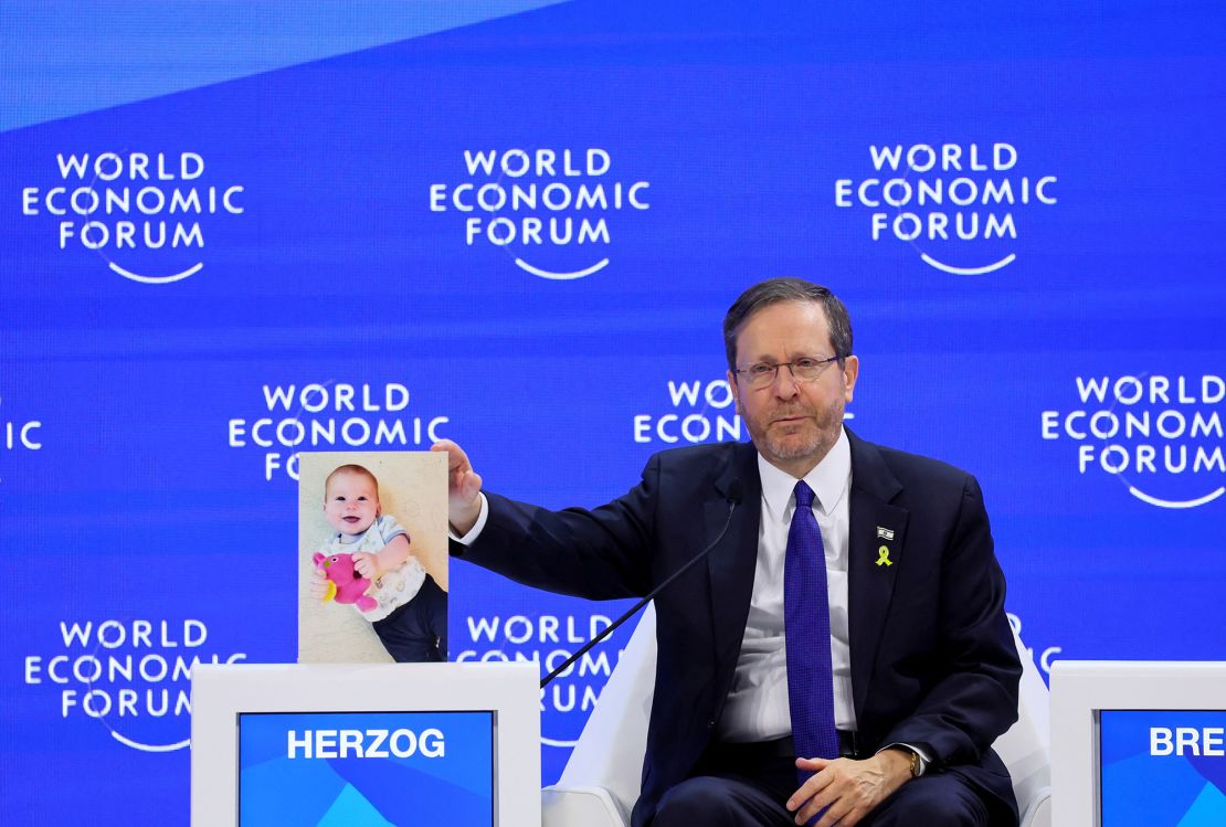 A picture of Kfir Bibas, a child who has been taken hostage by Palestinian Islamist group Hamas, is placed next to Israeli President Isaac Herzog, as he attends the 54th annual meeting of the World Economic Forum, in Davos, Switzerland, January 18, 2024. REUTERS/Denis Balibouse