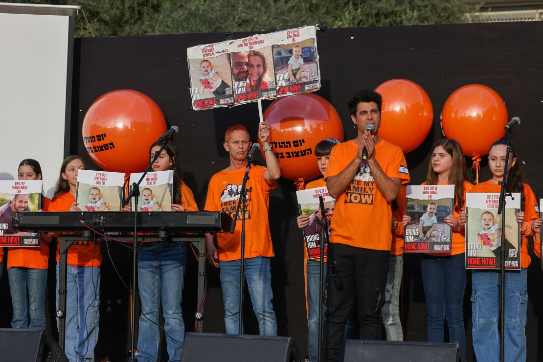 Children hold portraits of of Kfir Bibas, the youngest hostage to be kidnapped by Hamas militants on the October 7 attack, his brother Ariel Bibas, their father Yarden Bibas, and their mother Shiri Bibas as Israelis attend his first birthday celebration in Tel Aviv, on January 18, 2024. Kfir Bibas was born on January 18 and -- if still alive -- would be celebrating his first birthday. In November, Hamas broadcast a video announcing the death of the baby, his brother and mother, but there has been no confirmation from Israeli officials, and relatives are still clinging to the hope that they are not dead. (Photo by AHMAD GHARABLI / AFP) (Photo by AHMAD GHARABLI/AFP via Getty Images)