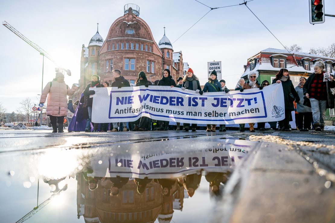People gather and hold a banner that reads: "Never again is now! You have to do anti-fascism yourself", in Erfurt, Germany, Saturday Jan. 20, 2024, to protest against right-wing extremist activities.