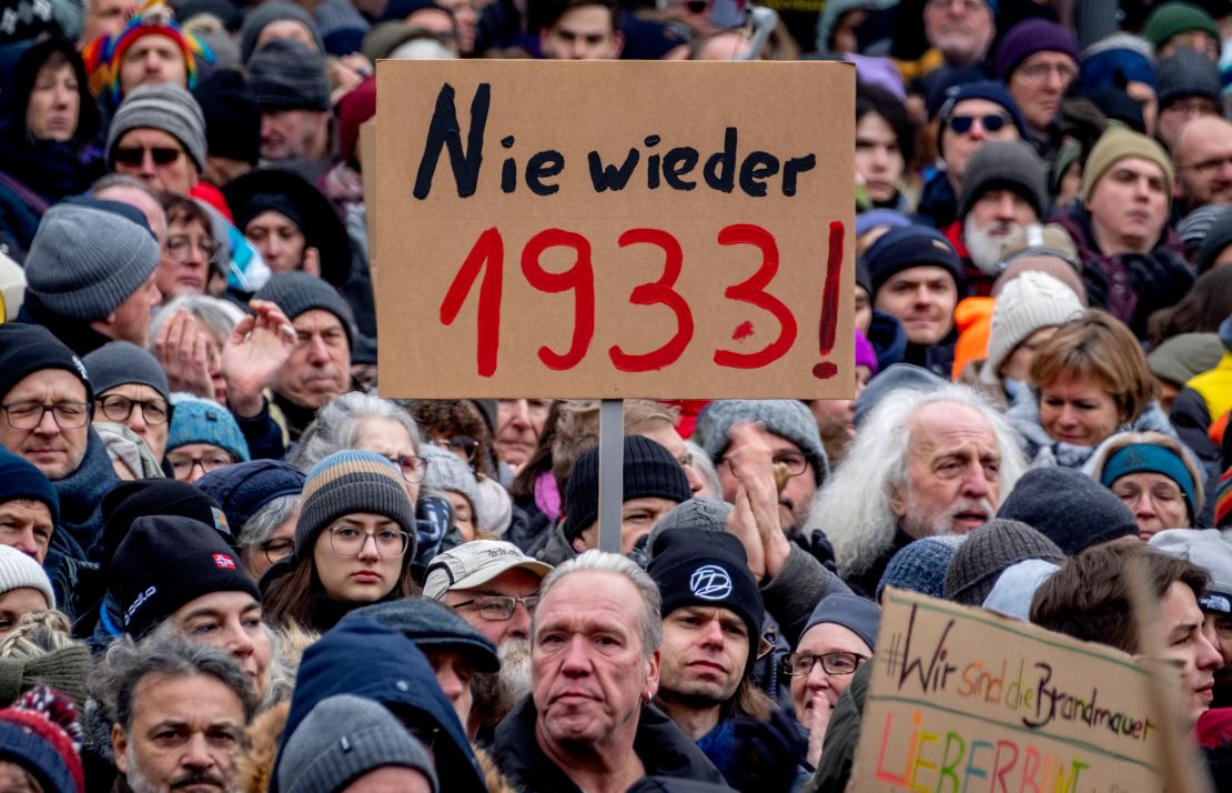 People gather as they protest against the AfD party and right-wing extremism in Frankfurt/Main, Germany, Saturday, Jan. 20, 2024. Sign reads "never again 1933".