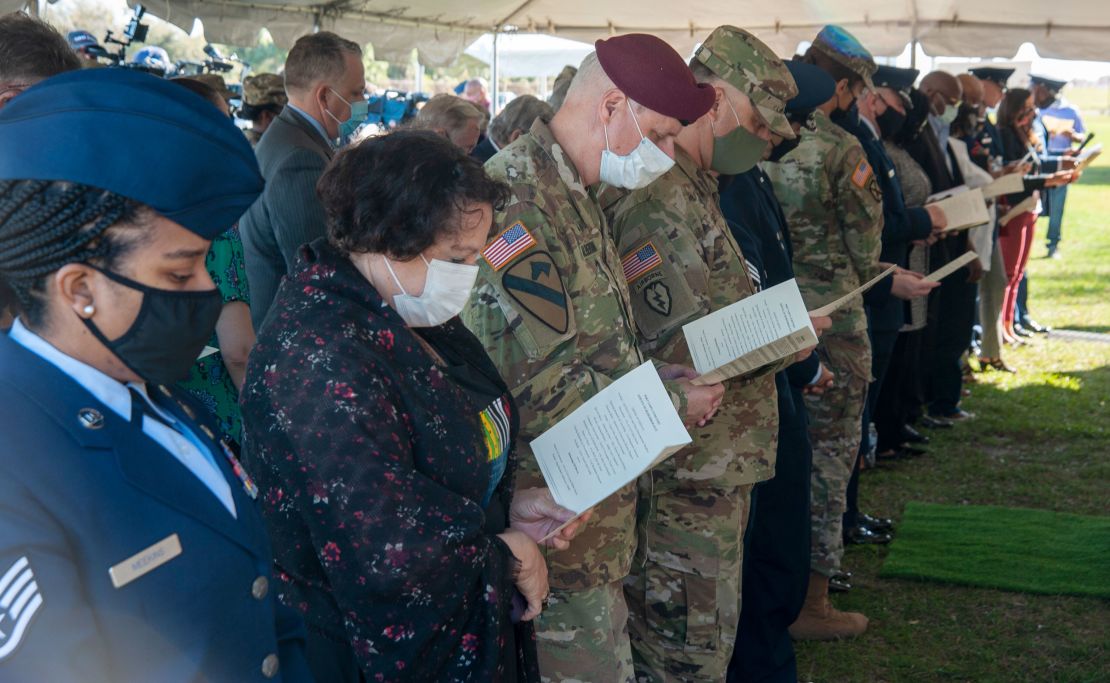 Military and civilian personnel bow their heads while reading a litany aloud during the Port Tampa Cemetery Service of Remembrance at MacDill Air Force Base, Fla., Feb. 23, 2021. MacDill AFB partnered with the local community in remembrance of the sacred final resting place of those buried at the Port Tampa Cemetery.