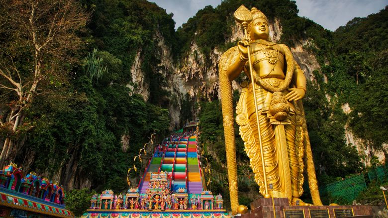 CUEVAS DE BATU, GOMBAK, SELANGOR, MALASIA - 16/11/2018: La majestuosa estatua dorada de Lord Murugan vista en el sitio turístico.  Las icónicas Cuevas de Batu, el punto turístico, ahora lucen una apariencia nueva y vibrante con los 272 escalones de la escalera que conduce a la Cueva del Templo siendo repintados con una gran variedad de colores.  Las cuevas de Batu son también un lugar de peregrinación que recibe a devotos hindúes de todo el mundo durante las celebraciones anuales de Thaipusam.  (Foto de Azim Khan Ronnie/SOPA Images/LightRocket vía Getty Images)