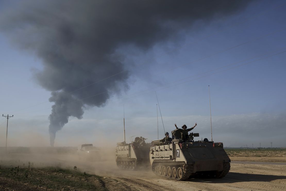 Israelische Soldaten bewegen sich auf gepanzerten Mannschaftstransportern in der Nähe der israelischen Grenze zu Gaza, während im Gazastreifen Rauch in den Himmel steigt, gesehen vom Süden Israels, Sonntag, 21. Januar 2024. (AP Photo/Leo Correa)
