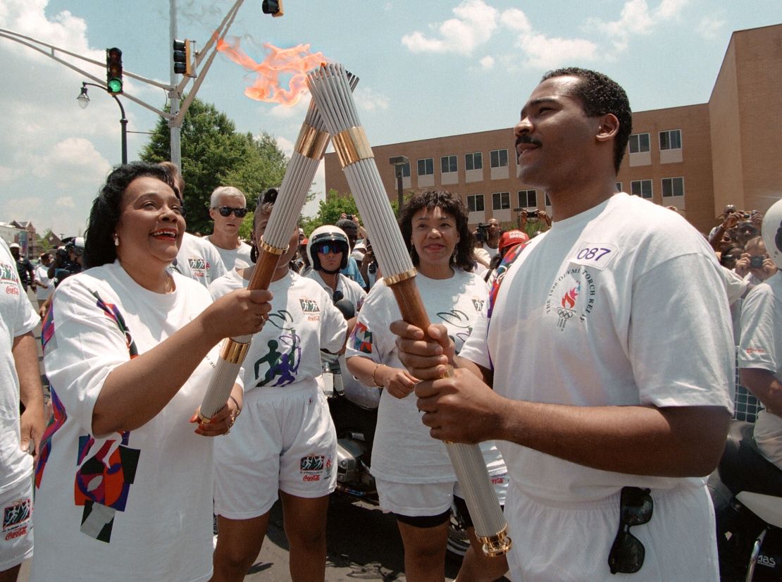 ATLANTA, UNITED STATES:  Coretta Scott King (L), widow of civil rights leader Martin Luther King, passes the Olympic Flame to her son Dexter Scott King 19 July 1996 in Atlanta. The Kings were part of the relay that has taken the flame around Atlanta before the opening ceremonies later 19 July 1996. (Photo credit should read MICHEL GANGNE/AFP via Getty Images)