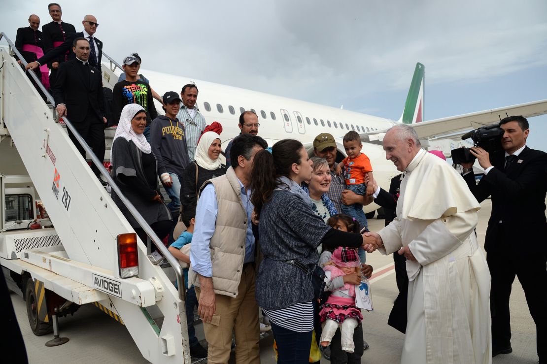 Pope Francis greets a group of Syrian refugees upon landing at Rome's Ciampino airport Saturday, April 16, 2016. Pope Francis gave Europe a provocative and concrete lesson in how to treat refugees Saturday by bringing home 12 Syrian Muslims aboard his charter plane after an emotional visit to the hard-hit Greek island of Lesbos. (Filippo Monteforte/Pool Photo via AP)