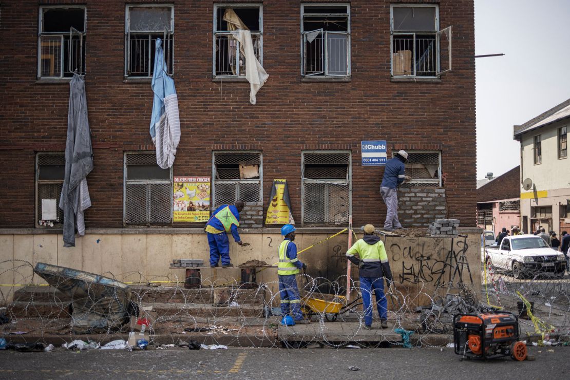 Workers seal off the perimeter of a burned apartment block in Johannesburg on September 6, 2023. At least 76 people including 12 children died as fire ripped through the five-storey building in the early hours on August 31, 2023. (Photo by Michele Spatari / AFP) (Photo by MICHELE SPATARI/AFP via Getty Images)