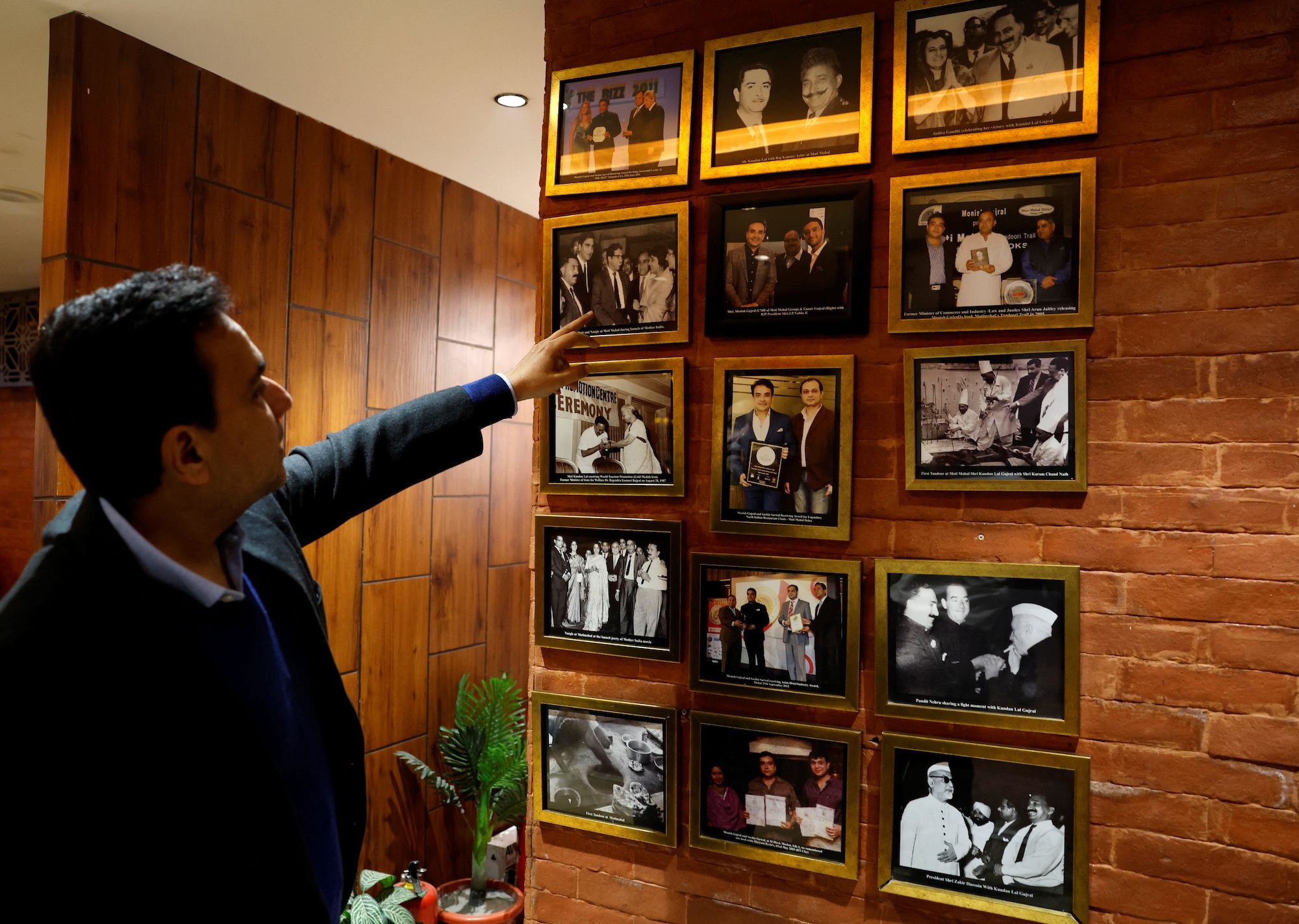 Moti Mahal Delux Managing Director Monish Gujral shows photographs of celebrities and politicians inside the restaurant in New Delhi, India, January 23, 2024. REUTERS/Sahiba Chawdhary NO RESALES. NO ARCHIVES.