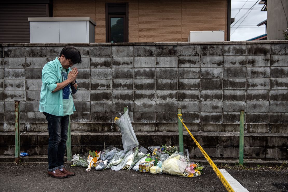 A man prays after laying flowers near the Kyoto Animation Co studio building after an arson attack, on July 19, 2019 in Kyoto, Japan.