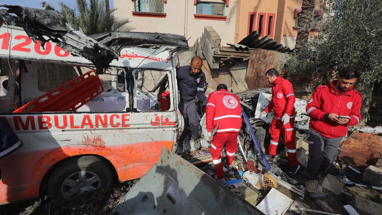 Palestinian Red Crescent personnel check a destroyed ambulance in Deir el-Balah in the central Gaza Strip, on January 11, 2024, amid the ongoing conflict between Israel and the Palestinian militant group Hamas. The Palestinian Red Crescent Society said an Israeli strike on an ambulance in the central Gaza Strip on January 10, killed four medics and two other people inside the vehicle. (Photo by AFP) (Photo by -/AFP via Getty Images)