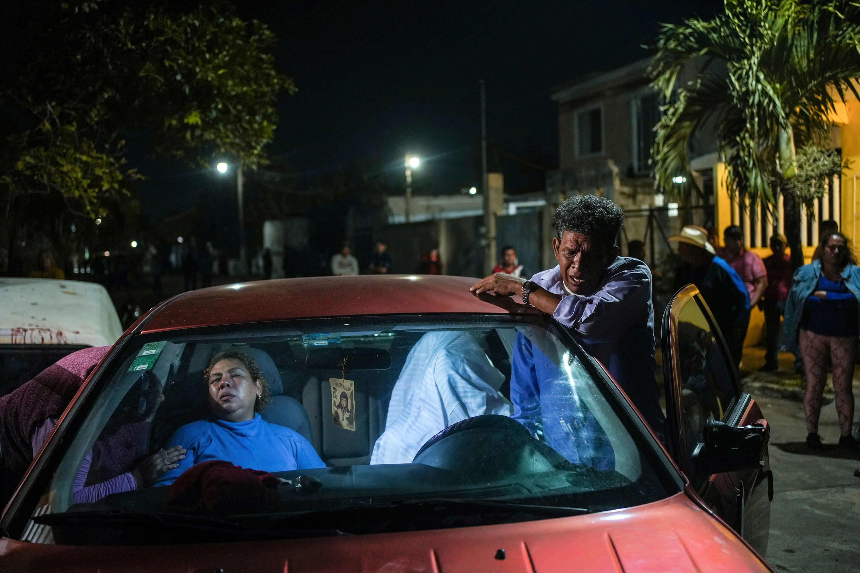 The parents of Brando de Jesús Arellano Cruz grieve next to his body after he was fatally shot by police while in his vehicle in Lerdo de Tejada, Mexico, on Friday, January 19. Four police officers were placed under investigation after people in the town surrounded the officers and attacked them, according to the Associated Press.