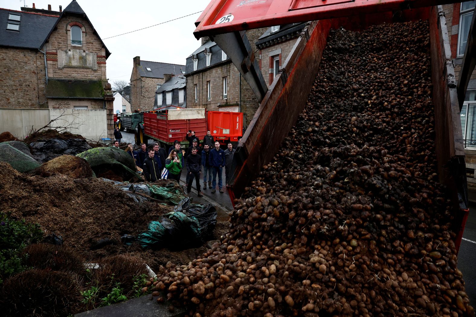 Farmers in Guingamp, France, dump potatoes, blocking the Sub-Prefecture there as part of a protest on Wednesday, January 24. Farmers across the country are demanding action on price pressures, taxes and green regulation.