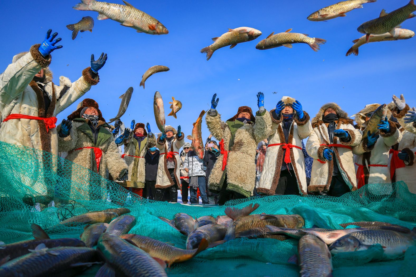 Fishermen throw fish they caught at Bosten Lake, in China's Bayingolin Mongol Autonomous Prefecture, on Saturday, January 20.