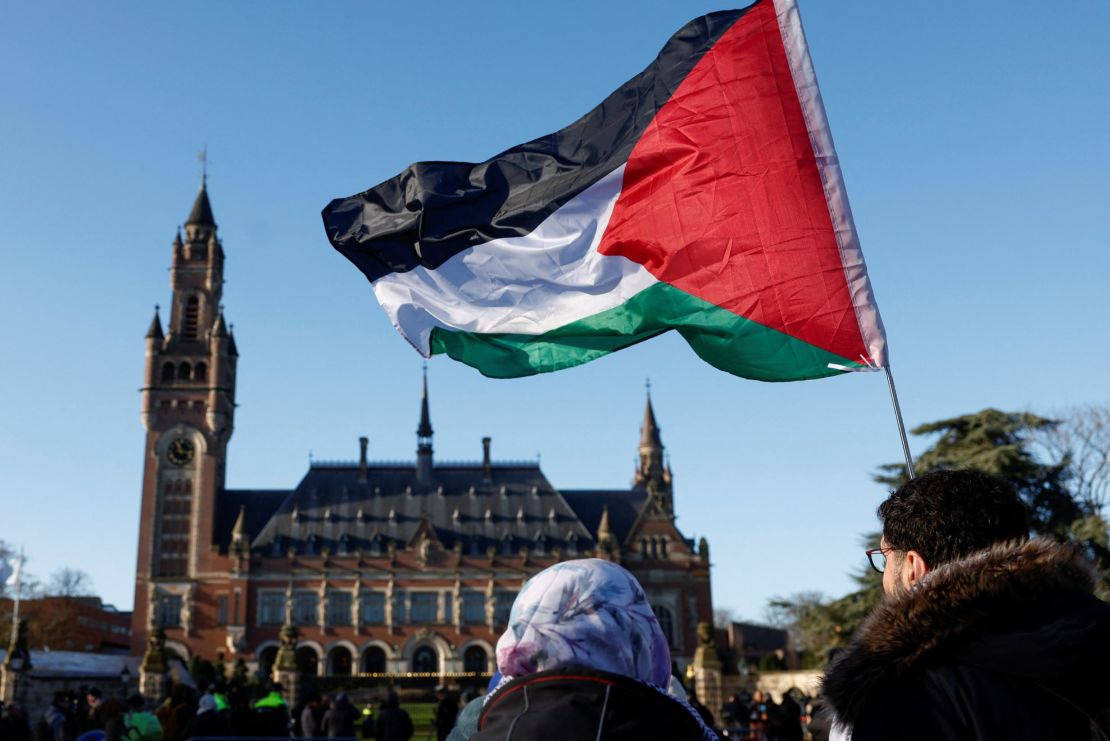 Protesters hold a Palestinian flag as they gather outside the International Court of Justice (ICJ) as judges rule on emergency measures against Israel following accusations by South Africa that the Israeli military operation in Gaza is a state-led genocide, in The Hague, Netherlands, January 26, 2024. REUTERS/Piroschka van de Wouw