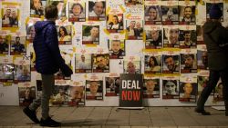 People walk by a wall with photos of hostages held in the Gaza Strip by Hamas during a rally calling for release of all hostages on January 27, 2024 in Tel Aviv, Israel. 