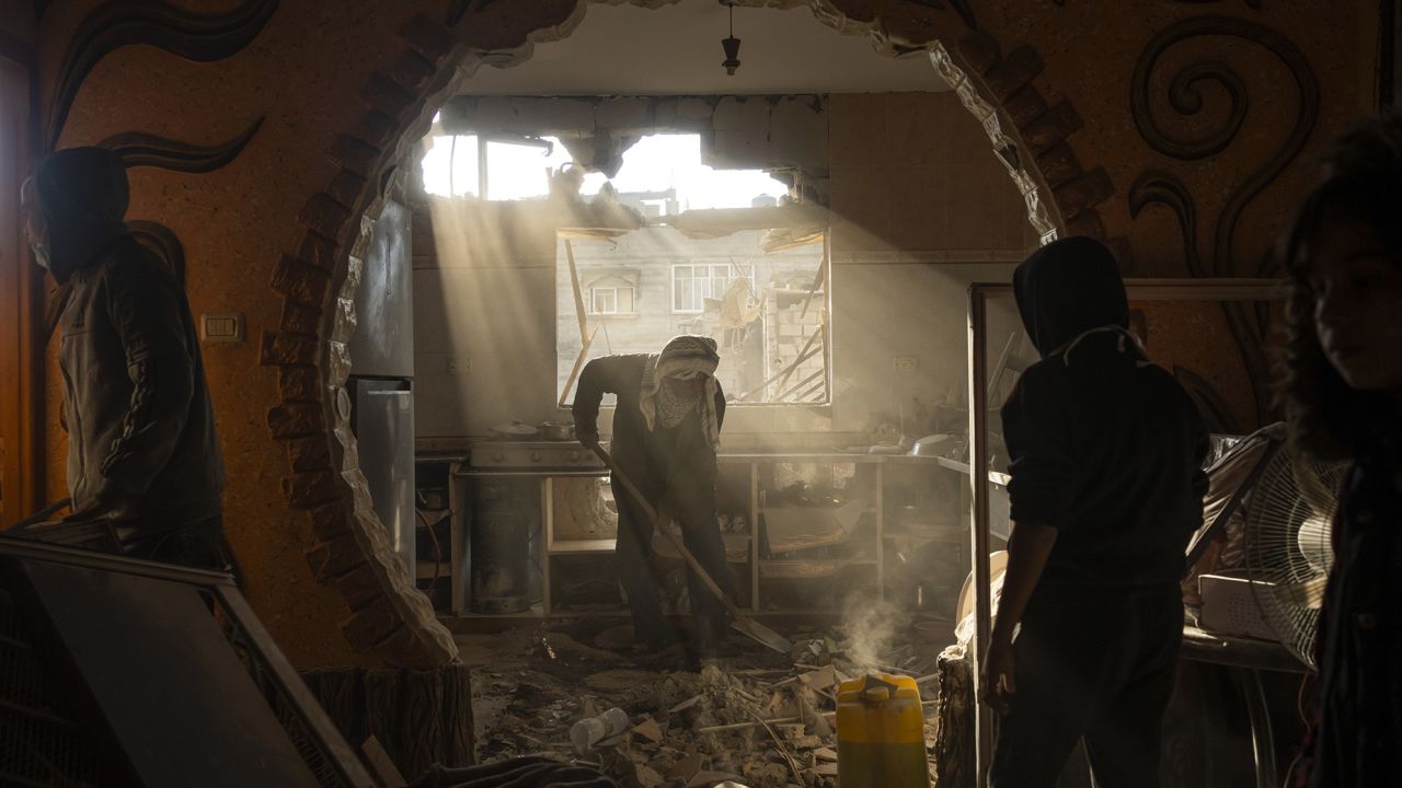 Palestinians look at their neighbour's damaged house following an Israeli strike in Rafah, southern Gaza Strip, Saturday, Jan. 27, 2024. (AP Photo/Fatima Shbair)