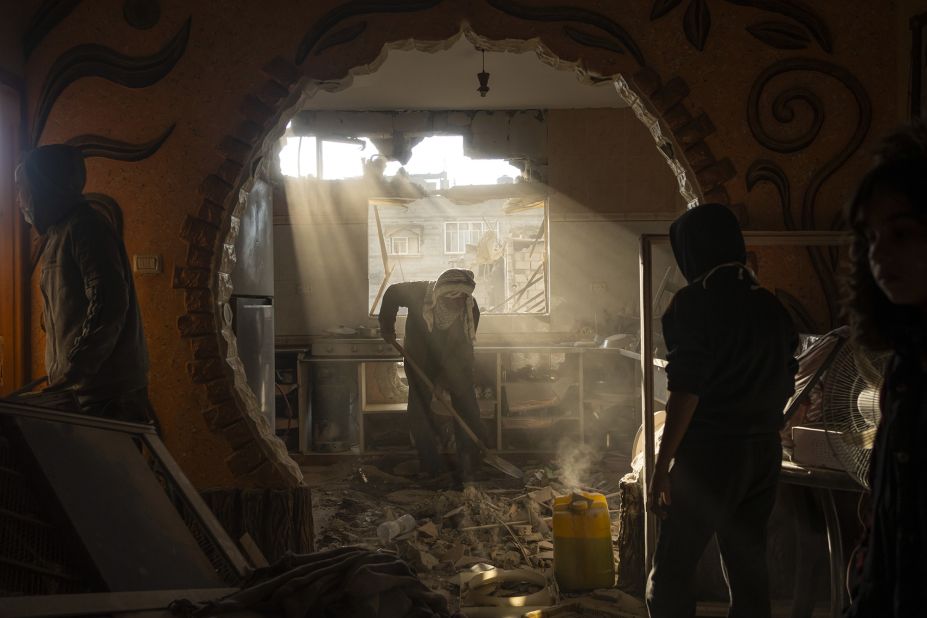Palestinians look at their neighbor's damaged house following an Israeli strike in Rafah, Gaza, on January 27.