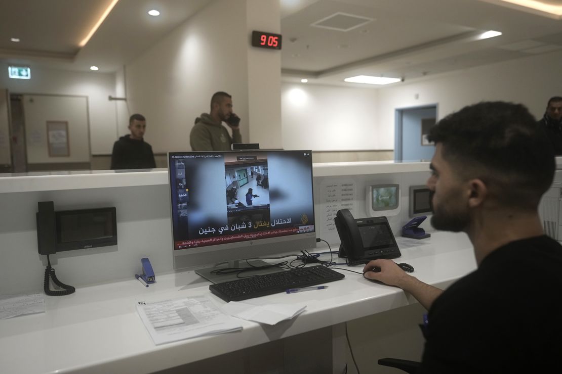 A staff member at Ibn Sina Hospital shows a news broadcast of security camera footage showing a deadly Israeli military raid in the West Bank town of Jenin, Tuesday, Jan. 30, 2024. Armed Israeli undercover forces disguised as women and medical workers stormed the hospital on Tuesday, killing three Palestinian militants. The Palestinian Health Ministry condemned the incursion on a hospital, where the military said the militants were hiding out.(AP Photo/Majdi Mohammed)