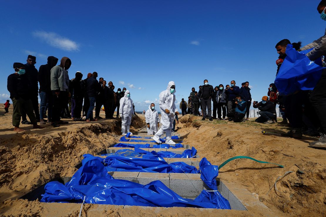 People bury Palestinians, including those killed in Israeli strikes and fire, at a mass grave in Rafah, January 30, 2024.