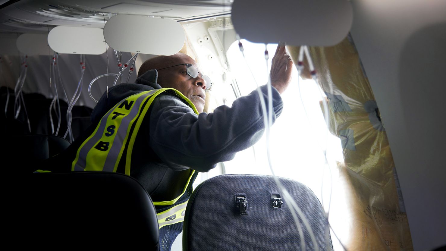In this National Transportation Safety Board (NTSB) handout, NTSB Investigator-in-Charge John Lovell examines the fuselage plug area of Alaska Airlines Flight 1282 Boeing 737-9 MAX on January 7, 2024 in Portland, Oregon. A door-sized section near the rear of the Boeing 737-9 MAX plane blew off 10 minutes after Alaska Airlines Flight 1282 took off from Portland, Oregon on January 5 on its way to Ontario, California.