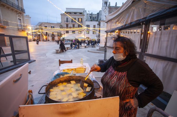 A woman cooks fried polenta, also called "sgagliozza" in Bari, Italy.  