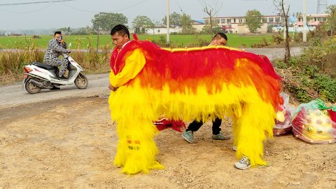 Villagers wearing a lion dance costume for two performers, Huozhuang Village, Henan Province, 2018; from Community Fire (Aperture, 2023).