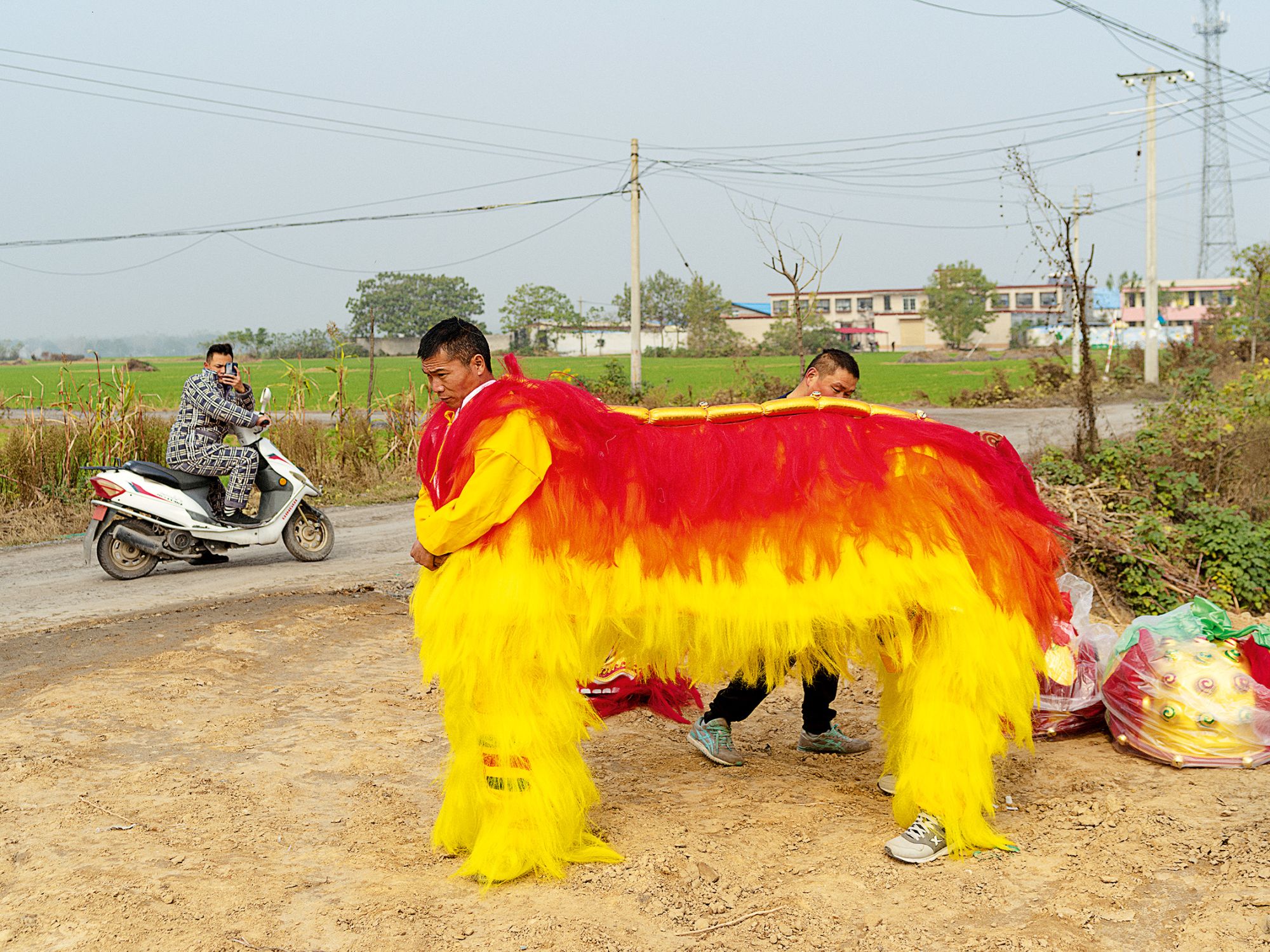 Villagers wearing a lion dance costume for two performers, Huozhuang Village, Henan Province, 2018; from Community Fire (Aperture, 2023).
