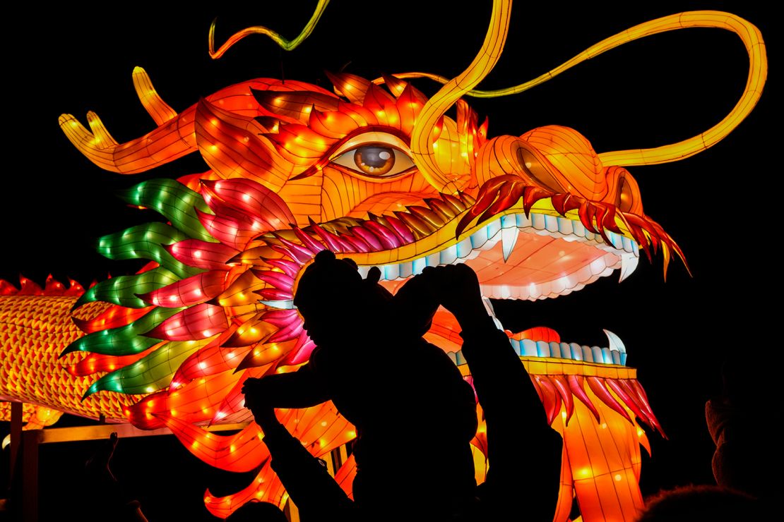 A man and a toddler pose for a photo next to a dragon lantern decorated near the popular Houhai Lake in Beijing, on February 8, 2024.