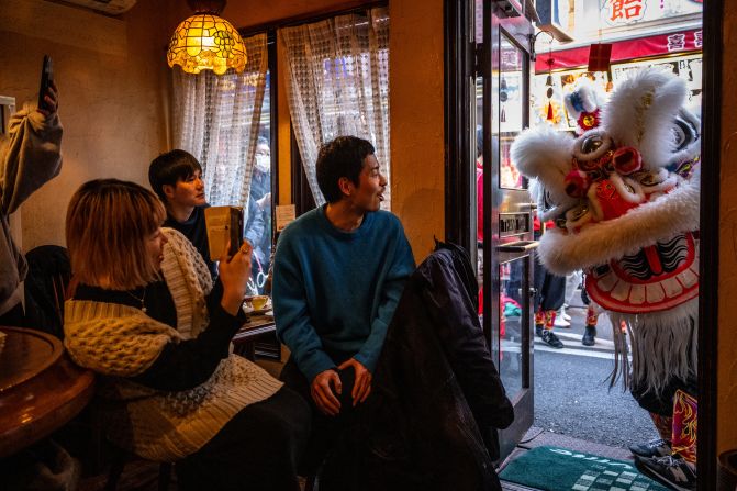 Diners at a restaurant watch a lion dance in the Chinatown area of Yokohama, Japan, on February 10.