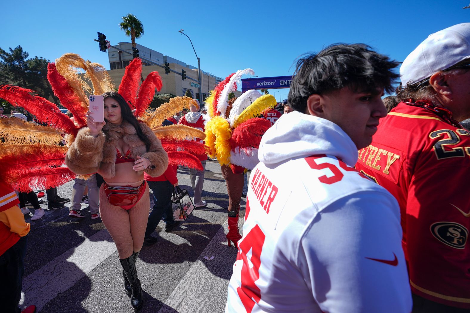 Las Vegas showgirls wait to pose for pictures with fans outside the stadium.