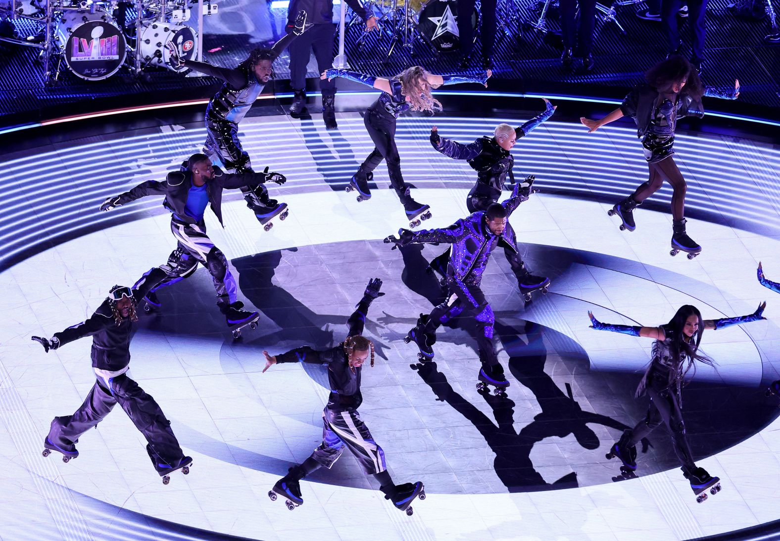 Usher and backup dancers perform on roller skates.