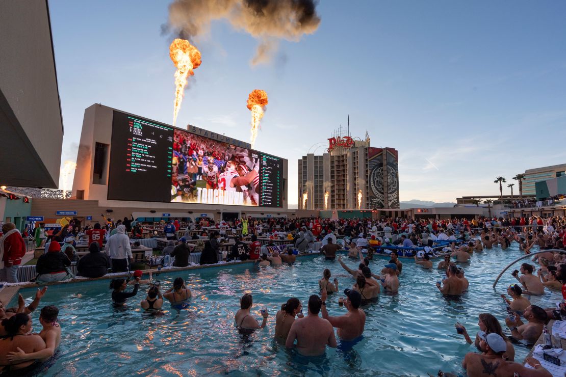 Los fanáticos de los 49ers de San Francisco celebran un touchdown mientras miran el partido de fútbol americano de la NFL Super Bowl 58 contra los Chiefs de Kansas City desde una piscina en la parte superior del Circa Resort and Casino, el domingo 11 de febrero de 2024 en Las Vegas. (Foto AP/Gregory Bull)