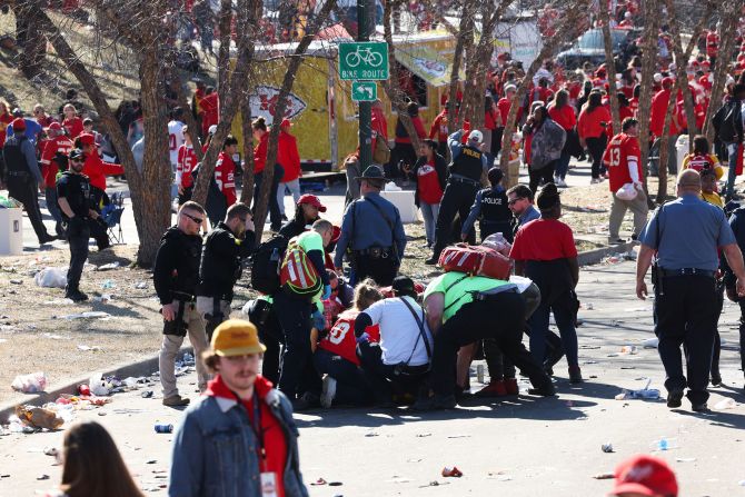 Law enforcement and medical personnel gather around an injured person.