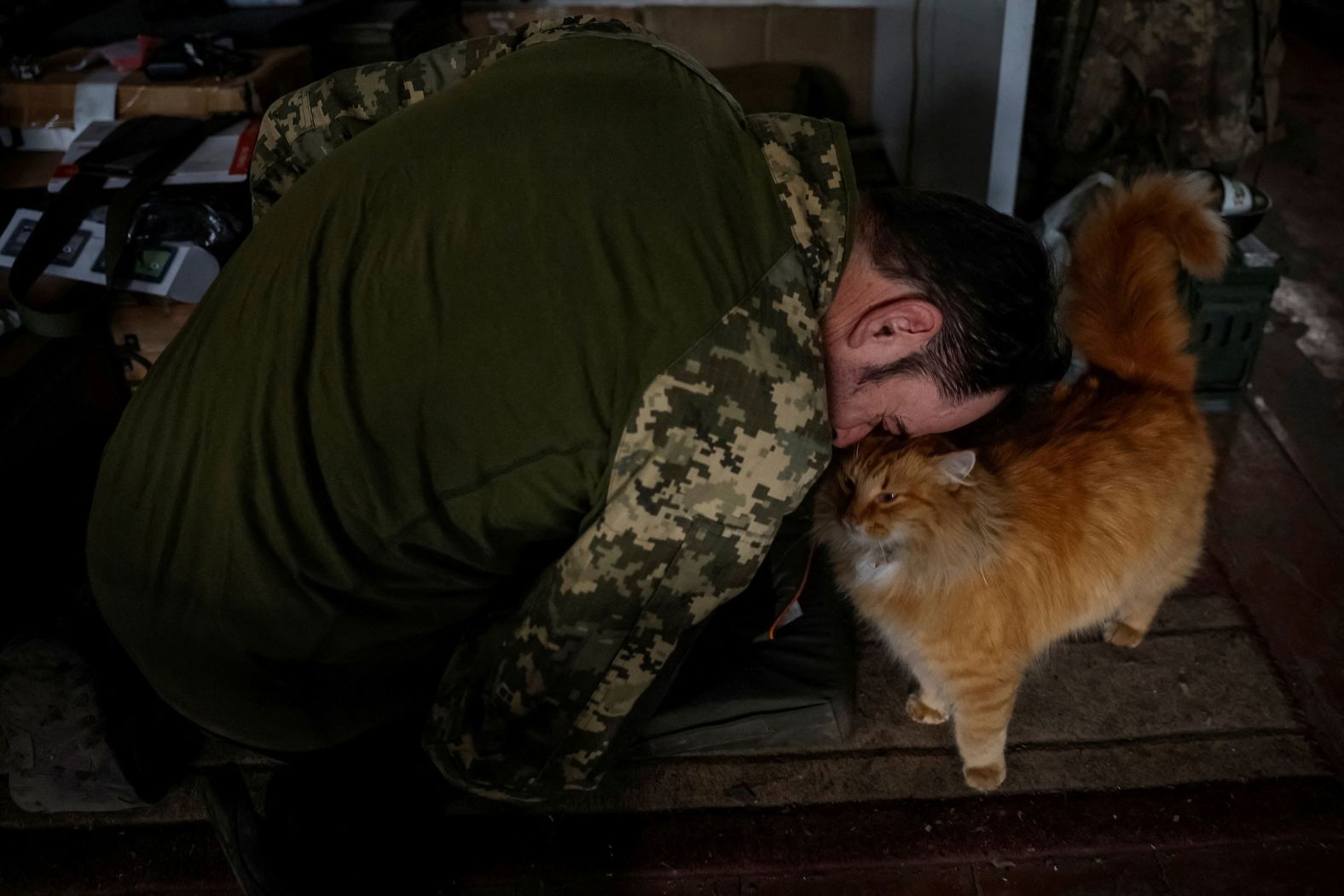 A Ukrainian serviceman plays with a cat, which his unit saved from the front lines of the war with Russia, on Thursday, February 8. 