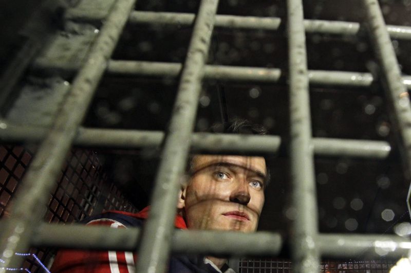 FILE - Alexei Navalny is seen behind the bars in the police van after he was detained during protests in Moscow, on May 8, 2012 a day after Putin's inauguration. Russia's prison agency says that imprisoned opposition leader Alexei Navalny has died. He was 47. The Federal Prison Service said in a statement that Navalny felt unwell after a walk on Friday Feb. 16, 2024 and lost consciousness. (AP Photo/Sergey Ponomarev, File)