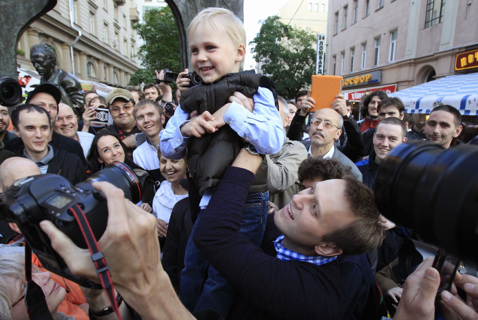 Navalny lifts his son, Zakhar, while meeting with supporters in Moscow in May 2012.