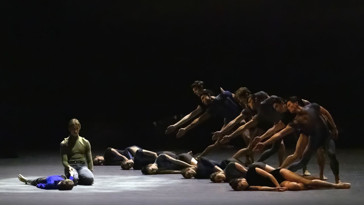 Joseph Gordon, left in green, and Theo Rochios (student of the School of American Ballet), and company in Solitude (World Premiere), choreography by Alexei Ratmansky, music by Gustav Mahler, Scenery and Costumes by Moritz Junge, Lighting by Mark Stanley. New York City Ballet, David H. Koch Theater, Lincoln Center, Thursday, February 15, 2024, 7:30pm. Credit Photo: Erin Baiano