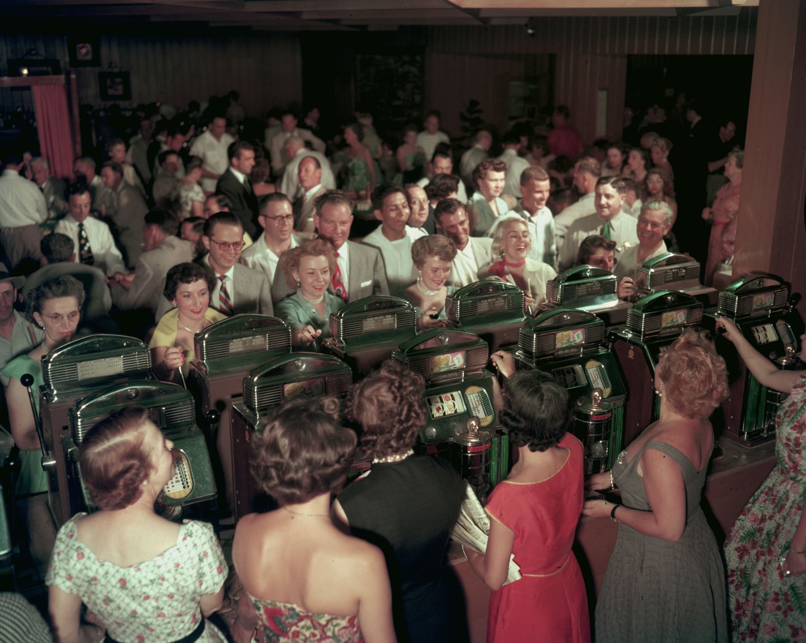 Women play slot machines in a crowded room at the Desert Inn casino in 1953.