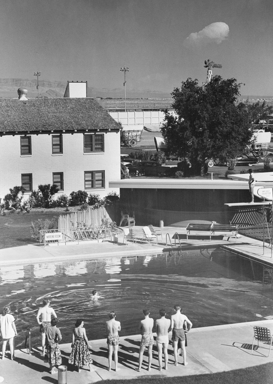 Swimmers at the Last Frontier hotel look into the distance as a nuclear weapons test takes place far away in the Nevada desert on May 8, 1953. Some desert areas of Nevada were sites for nuclear bomb testing, which attracted curiosity from across the country.