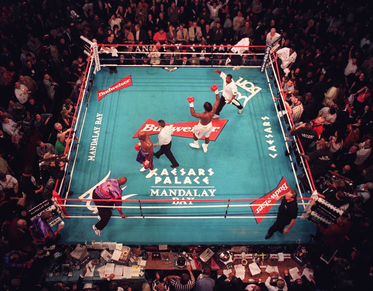 Lennox Lewis raises his arms after the final round of his heavyweight title bout with Evander Holyfield in 1999. The judges ruled it a draw, and the decision was highly controversial as most felt that Lewis had won. Lewis would later win a rematch by unanimous decision.