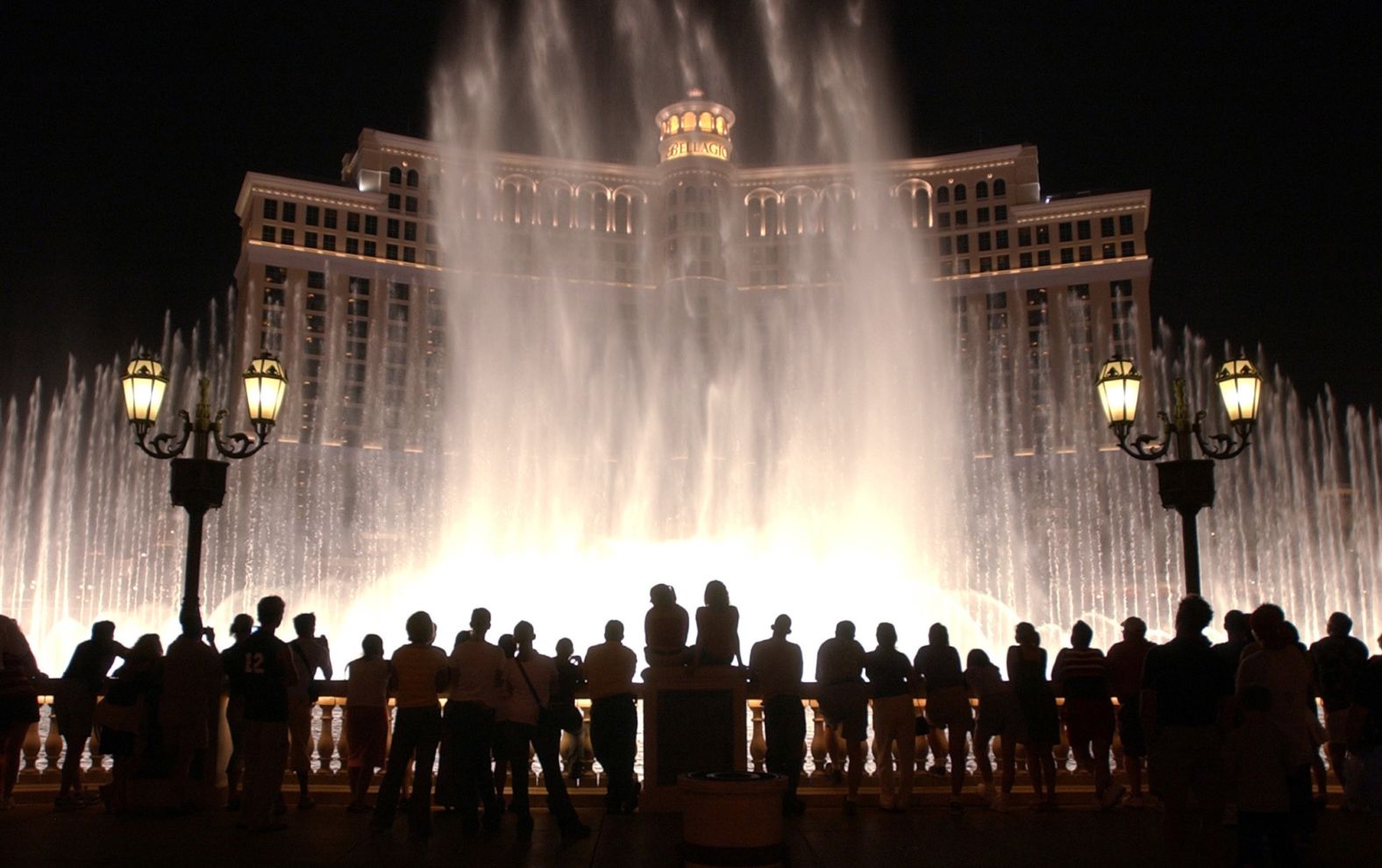 Tourists watch the fountain display at the Bellagio Hotel and Casino in 2002.