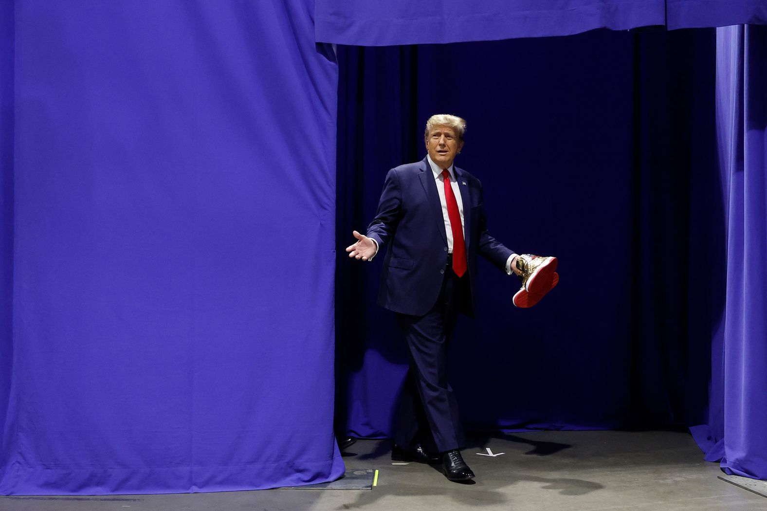 Former US President Donald Trump carries a pair of his new gold <a href="index.php?page=&url=https%3A%2F%2Fwww.cnn.com%2F2024%2F02%2F17%2Fpolitics%2Ftrump-sneakers-pay-millions-new-york-trial%2Findex.html" target="_blank">"Trump Sneakers"</a> before taking the stage at Sneaker Con in Philadelphia on Saturday, February 17. Trump launched the shoe line a day after he and his companies were <a href="index.php?page=&url=https%3A%2F%2Fwww.cnn.com%2F2024%2F02%2F16%2Fpolitics%2Ftakeaways-donald-trump-fraud-ruling%2Findex.html" target="_blank">ordered by a judge to pay nearly $355 million</a> in his New York civil fraud trial.