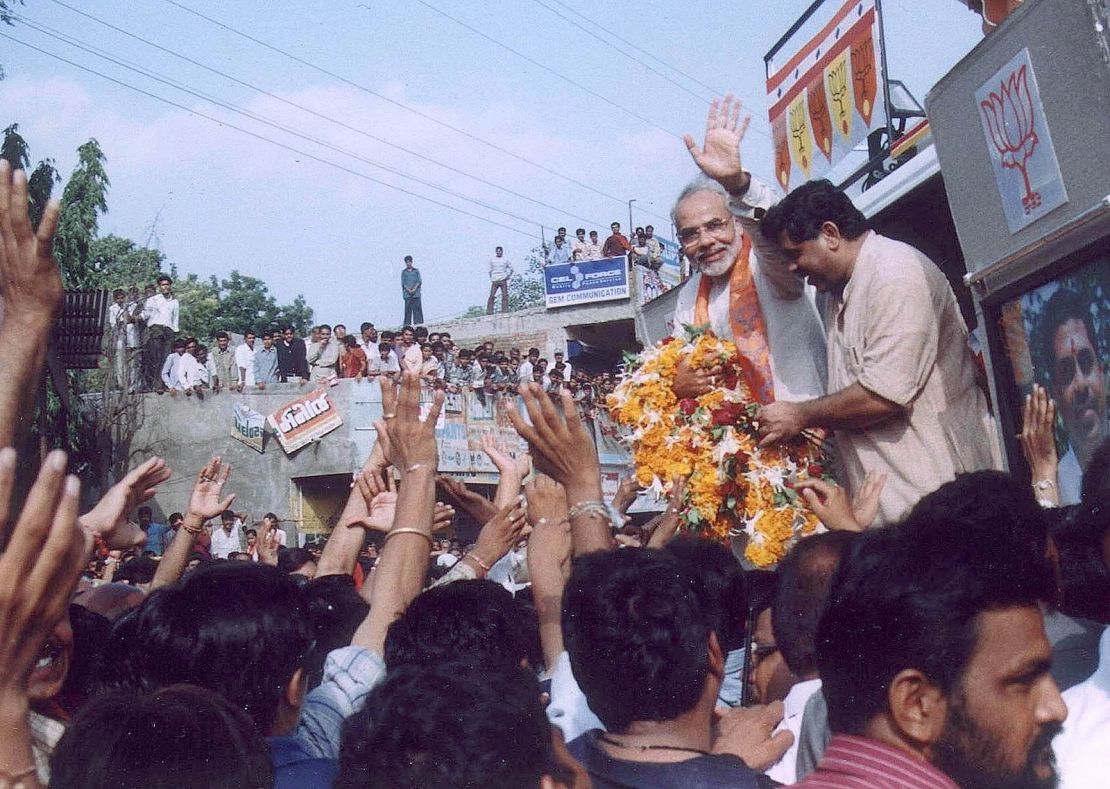 Gujarat Chief Minister Narendra Modi waves to supporters in Kadi, 40 km north of the state's main city Ahmedabad September 9, 2002. Fears of fresh religious violence in India's western Gujarat state receded on Monday as a controversial political march trundled peacefully through villages for a second day amidst tight police security.
