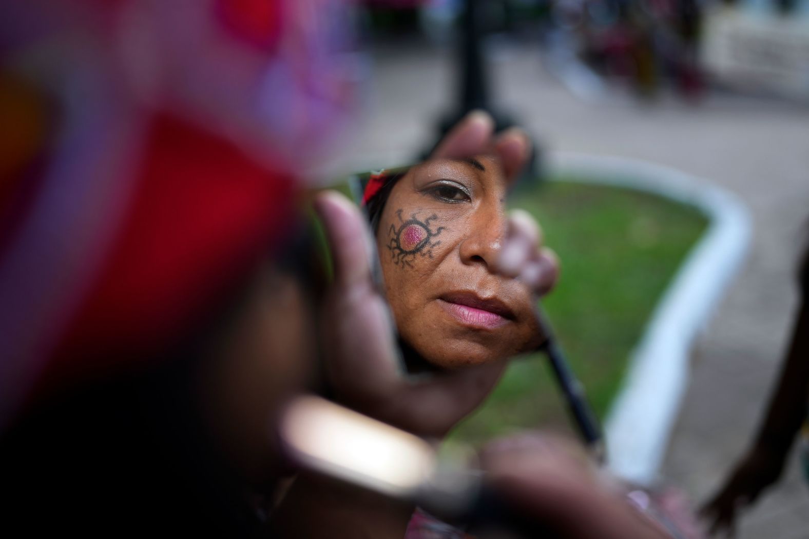 A Maka Indigenous woman puts on makeup before protesting for the recovery of ancestral lands in Asunción, Paraguay, on Wednesday, February 28.