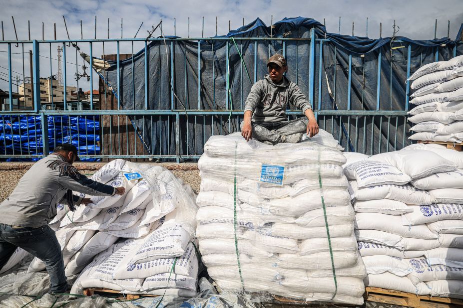 A worker rests as displaced Palestinians receive food aid in Rafah on January 28.