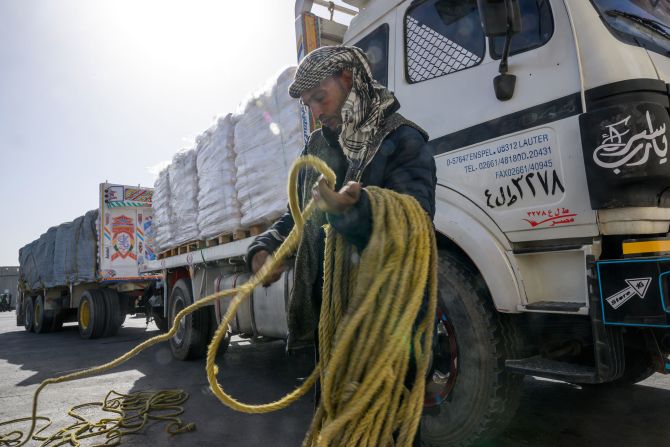 An Egyptian truck driver gathers rope used for covering a tarp while humanitarian aid is inspected in Israel before crossing into Gaza on December 22.
