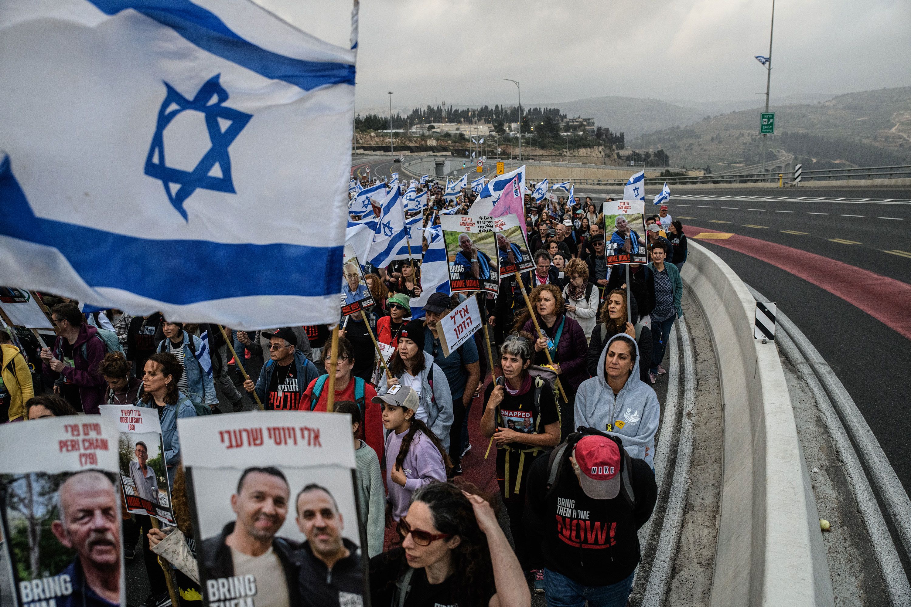 Families of Israeli hostages carry photos of their loved ones as they march to Jerusalem on Saturday, March 2.