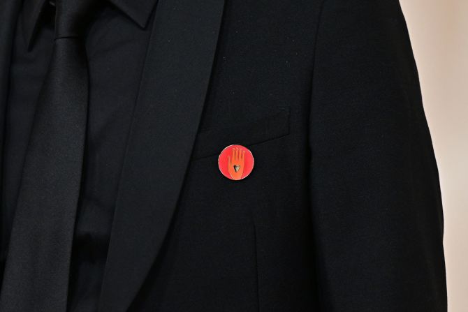 Film producer Nadim Cheikhrouha wears a red lapel pin on the red carpet. The same pin was also seen on Ramy Youssef, Mark Ruffalo and Billie Eilish. <a href="https://www.cnn.com/entertainment/live-news/oscars-academy-awards-03-10-24/h_e1d87d22f44731c0aefccb26fe997660" target="_blank">The pins call for a ceasefire</a> in the Israel-Hamas war.