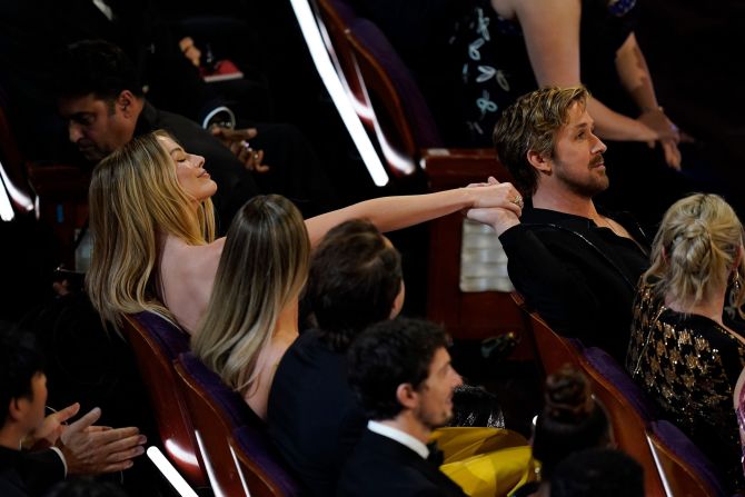 Gosling and "Barbie" co-star Margot Robbie hold hands during the show.